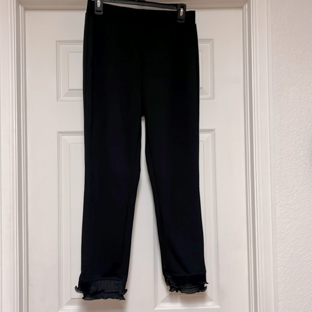 Womens medium sized black pants with lace cuffs at the bottom.